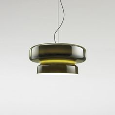 a light that is hanging from a wire in the air with a white wall behind it