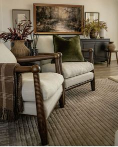 a living room filled with lots of furniture next to a painting on the wall over a window