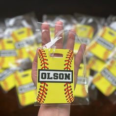 a person holding up a yellow plastic bag with baseballs on it and the name olson written on it