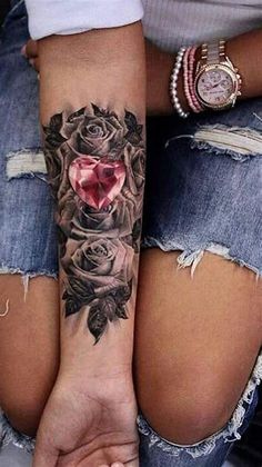 two women with tattoos on their arms and one has a heart in the middle of it