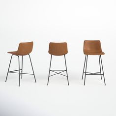 three stools in different sizes and colors on a white background, with one chair up against the other