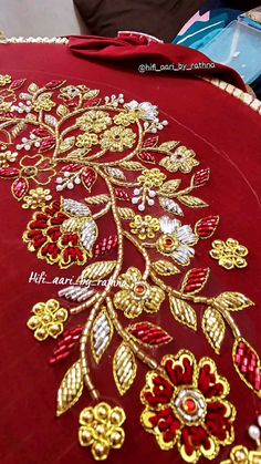 a red table cloth with gold embroidered flowers on it