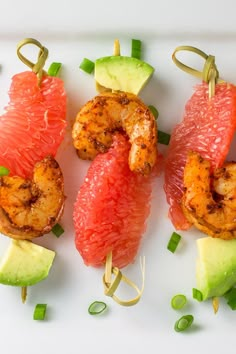 shrimp and avocado skewers on a white plate