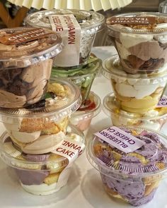 an assortment of desserts in plastic containers on a table