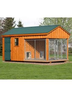 a small wooden dog house with a green roof and two dogs in the kennel