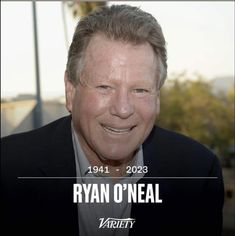 a man in a suit and tie smiling at the camera with an ad for ryan o'neal on it