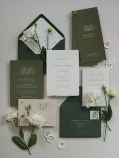 the wedding stationery is laid out on top of each other with flowers and paper