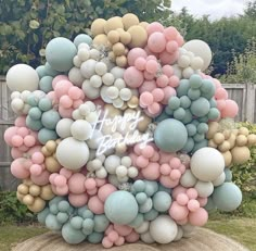 a bunch of balloons that are on the ground in front of some grass and trees