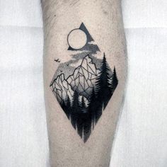 a man's leg with a mountain and forest tattoo on it