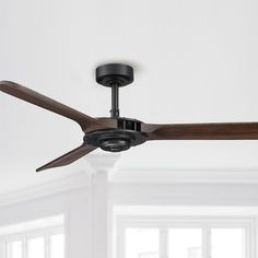 a ceiling fan in a room with white walls and wood trimmings on the ceiling