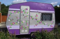 a purple trailer with flowers painted on it