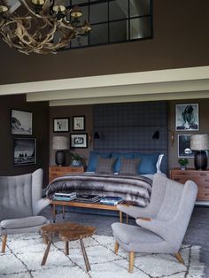 a bedroom with a bed, chairs and a chandelier hanging from the ceiling