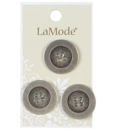 two buttons with the word la mode on them in front of a white and gray background