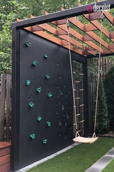 a backyard with a swing and climbing wall