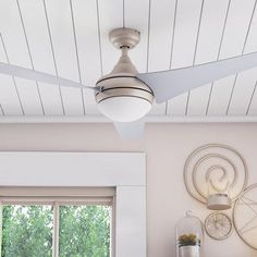 a white ceiling fan mounted on the side of a wall next to a bed in a bedroom