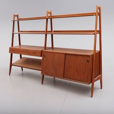 a mid century teak and oak bookcase with drawers