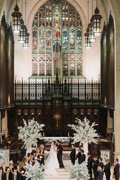 a couple getting married in front of an ornate alter at their wedding ceremony, with the bride and groom walking down the aisle