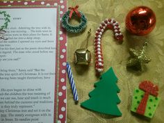 an open book with christmas decorations and ornaments on it next to a candy cane, bell, ornament