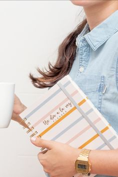 a woman holding a coffee cup and notebook in her right hand, with the words we love you on it