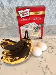 two bananas and three eggs sitting on a counter top next to a package of cheese