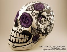 a white skull with purple flowers painted on it's face and the words artist collaboration