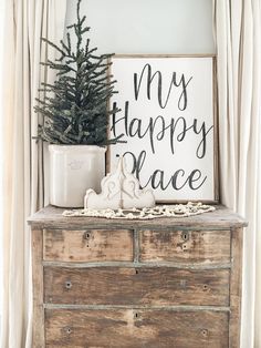 a christmas tree sits on top of an old dresser with a sign that says, my happy place