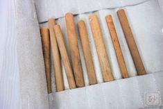 several wooden baseball bats laying on top of a white blanket