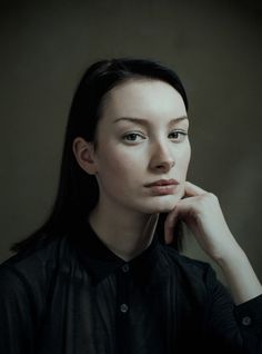 a woman is posing for a portrait with her hand on her chin