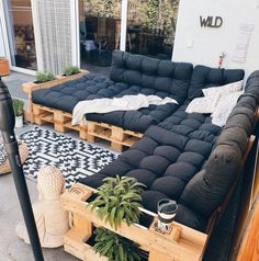 a black couch sitting on top of a wooden pallet