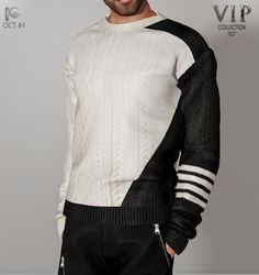 a man in a white and black sweater is posing for a photo with his hands on his hips