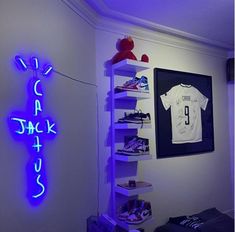 a room with a t - shirt on a shelf next to a blue neon sign