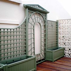 green planters are lined up against the wall and on the wooden floor next to each other