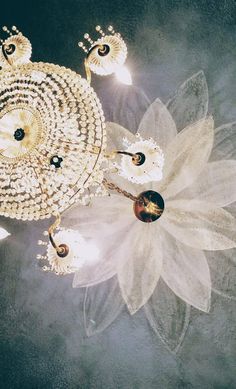 a chandelier hanging from the ceiling next to a flower shaped object with lights on it