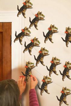 a woman is trying to make a cat wall decoration