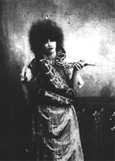 an old black and white photo of a woman with afro hair standing in front of a wall