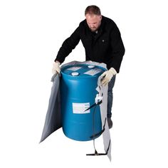 a man in black jacket and white gloves holding a blue barrel with grey bags on it