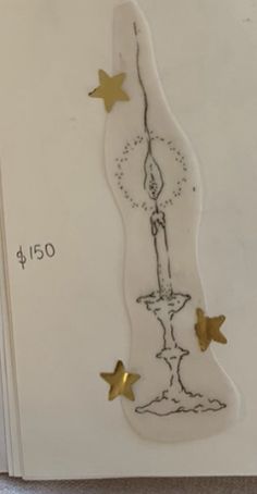 a white card with gold stars on it and a drawing of a fountain in the middle