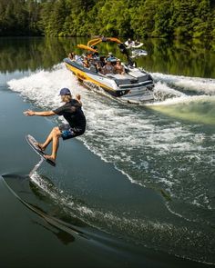 two people on water skis being pulled by a speedboat in the water with other boats behind them