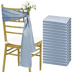 a stack of blue napkins next to a chair with a bouquet of flowers on it