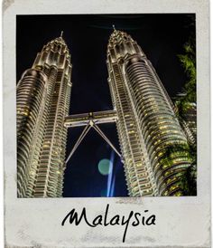 two very tall buildings towering into the night sky with lights shining on them and palm trees in front of them