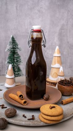 a bottle of chocolate syrup surrounded by cookies and spices