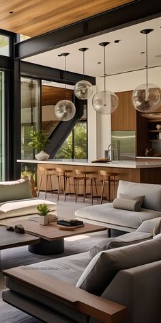 a living room filled with furniture next to a kitchen and an open floor plan area