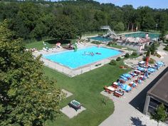 an aerial view of a swimming pool surrounded by trees