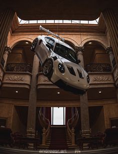 a car is flying through the air in front of a building with stairs and windows