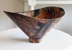 a wooden bowl sitting on top of a white table