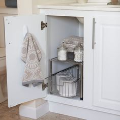 an open cabinet with towels and other items in it