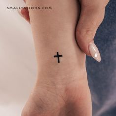 a woman's foot with a small cross tattoo on it