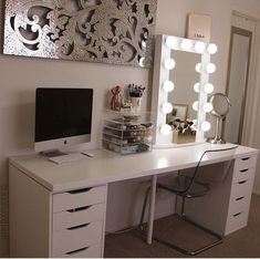 a white desk topped with a computer and a mirror