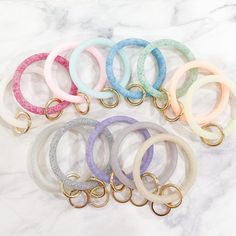 six different colored bracelets sitting on top of a marble counter