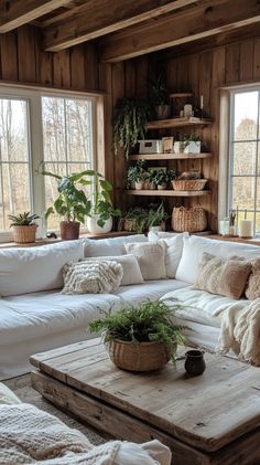 Rustic farmhouse living room with wood walls, white sofa, warm lighting, green plants, and a cozy, inviting atmosphere. Cozy Farmhouse Aesthetic, Natural Wood Walls, Boho Rustic Living Room, Earthy Living Room Ideas, Cozy Rustic Home, Stylish Baskets, Cottagecore Living Room, Rustic Comforter, Inviting Colors